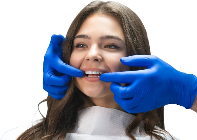 dentist with blue gloves pointing at a client's teeth