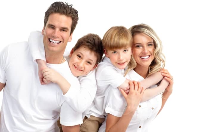 smiling man and woman with their two male kids