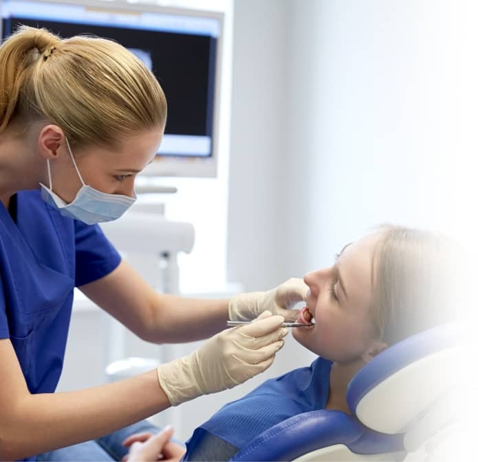 female dentist checking the teeth of a female patient