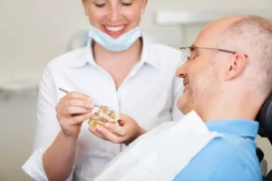 dentist showing a dental model to a male patient
